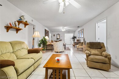 Tiled living room with ceiling fan and a textured