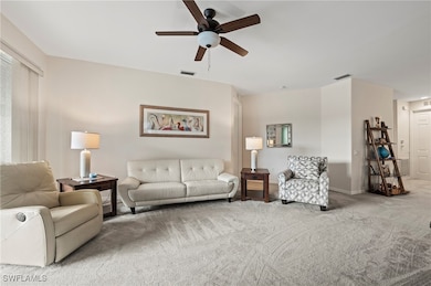 Living area with a ceiling fan and carpet flooring