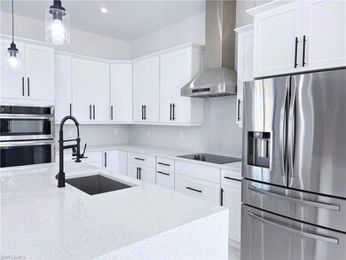Kitchen with wall chimney range hood, sink, applia