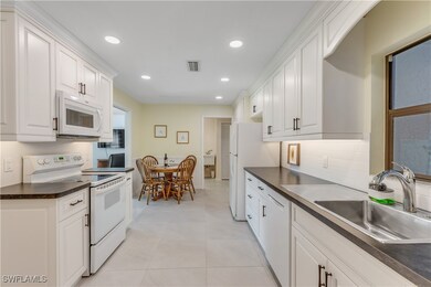 Kitchen with light tile patterned floors, white ap