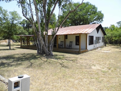 View of front of home featuring a front lawn, a porch, and a metal roof