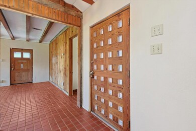 Entryway featuring wooden walls, tile flooring, an
