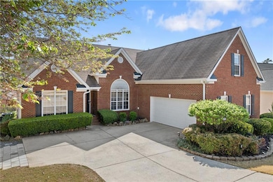 Traditional-style home with a shingled roof, brick