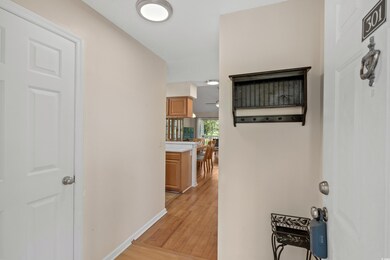 Hallway with light wood finished floors and basebo