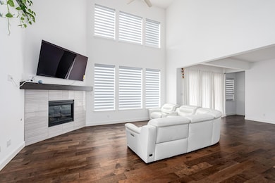 Living room featuring a tile fireplace, dark wood-