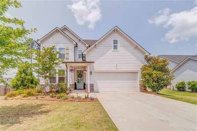 Traditional home with stone siding, concrete driveway, a front lawn, and a garage