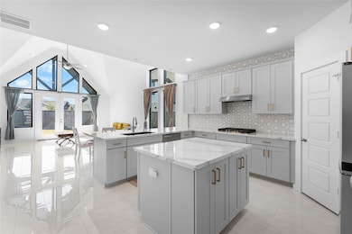 Large island, walk-in pantry, gas range, and quartz countertops.