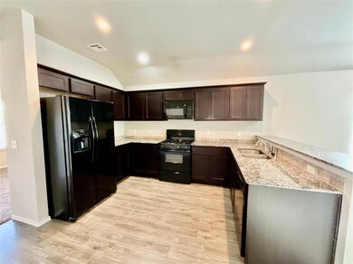 Kitchen with light stone counters, sink, kitchen p