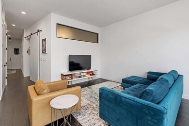 Living room featuring a barn door, wood finished 