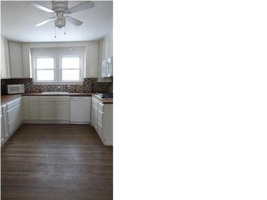 Kitchen overlooks the fenced yard area. The floors