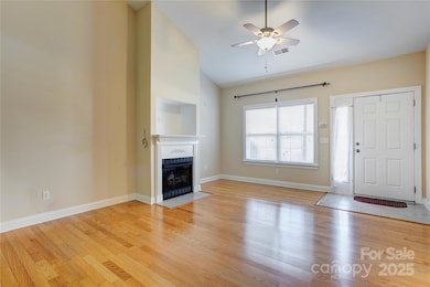 Living room features lots of natural light, vaulted ceiling and a gas fireplace
