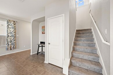 Stairway featuring tile patterned floors and arch