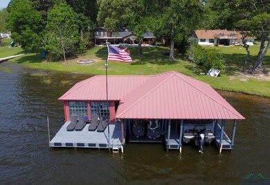 Dock area featuring a lawn, boat lift, and a water
