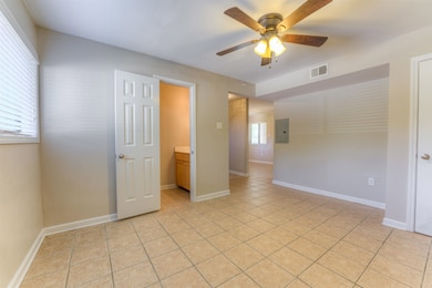 Unfurnished room with a ceiling fan, electric panel, and light tile patterned floors
