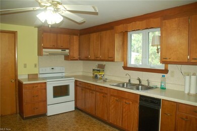 Kitchen featuring sink, electric stove, ceiling fan, black dishwasher, and dark tile flooring