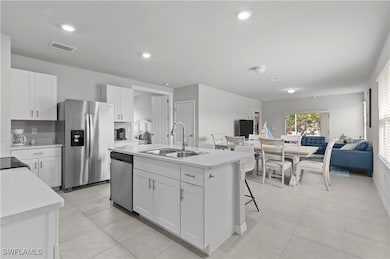 Kitchen with white cabinetry, sink, a kitchen isla