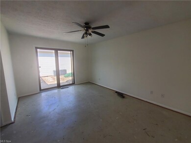 Empty room featuring ceiling fan and a textured ceiling