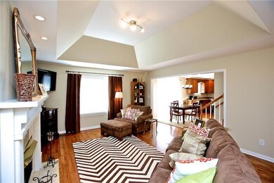 Vaulted ceilings, gleaming hardwood floors, and a gas log fireplace in this large living area create an open floor-plan that make this home great for entertaining.