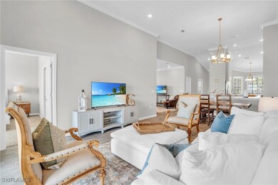 Living room with baseboards, an inviting chandelie