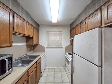 Kitchen featuring white appliances, a sink, light