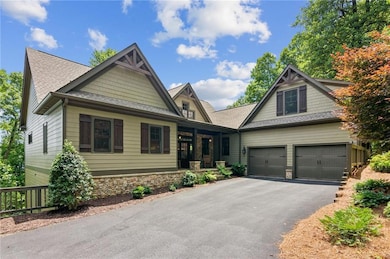 Craftsman inspired home featuring asphalt driveway, stone siding, a garage, and a shingled roof