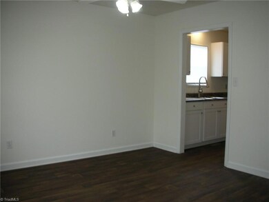 Dining Room: Features include laminate flooring for easy cleaning, a window for natural lighting and blinds for privacy, fresh paint and a ceiling fan with light. The open doorway is to the kitchen and then the laundry room.