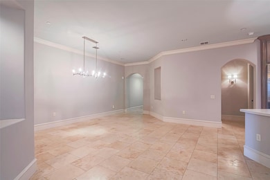 Spare room featuring arched walkways, crown moldin
