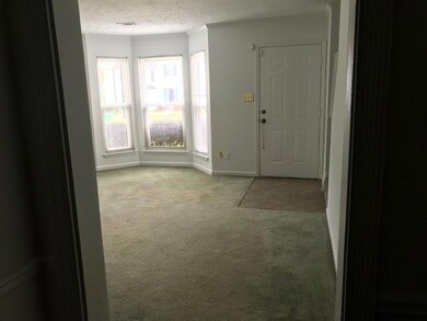 Entryway featuring a textured ceiling, carpet, and plenty of natural light