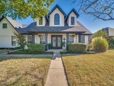 View of front of house featuring a front lawn, a porch, brick siding, and a shingled roof