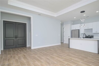 Kitchen with white cabinetry, a tray ceiling, stai