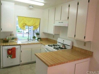 Cheery kitchen with newly painted cabinets, new ti