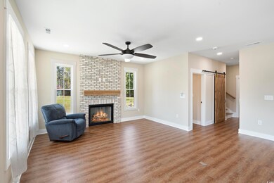 Living room with a ceiling fan, wood finished floo