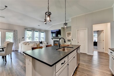Kitchen with a sink, dark countertops, a glass cov