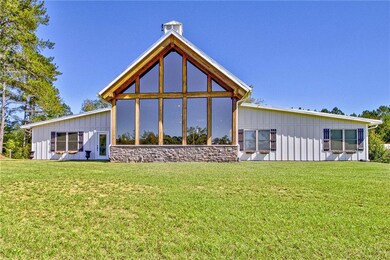 Rear view of house featuring a yard and a sunroom