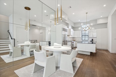 A designer chandelier crowns the 12’ ceiling in the dining area, adding a touch of glamour to the elegant setting. The mirrored wall amplifies light and scale, creating a dramatic sense of spaciousness.  Let me show you the first floor next.