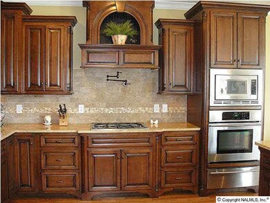 Closer view of kitchen with Warmer drawer, microwave, oven and pot filler.