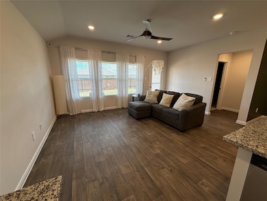 Living area featuring dark wood finished floors, ceiling fan, and recessed lighting