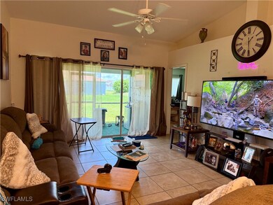 Living room featuring a ceiling fan, light tile pa