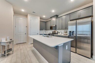 Kitchen featuring visible vents, a sink, backsplas