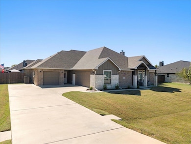 View of front of home with a shingled roof, driveway, an attached garage, board and batten siding, and stone siding