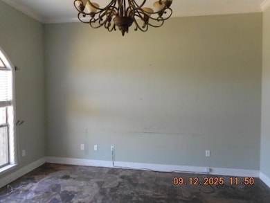 Empty room with crown molding and a chandelier