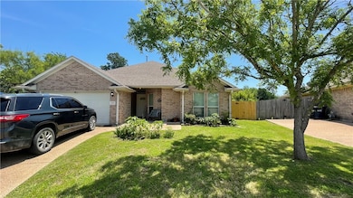 Ranch-style house with brick siding, a garage, dri