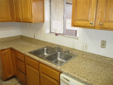 Kitchen featuring brown cabinetry, dishwasher, a s