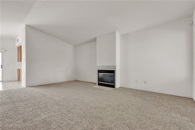 Unfurnished living room with light carpet, a tile