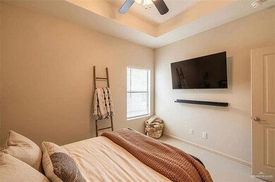 Carpeted bedroom featuring ceiling fan and baseboards