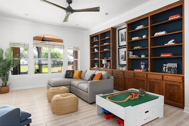 Living room featuring a ceiling fan, ornamental m