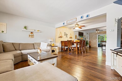 Living room featuring dark wood-type flooring and beam ceiling