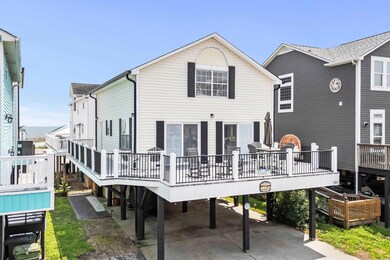 Back of property featuring a wooden deck and a car