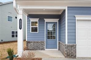 Entrance to property with a porch and an attached garage