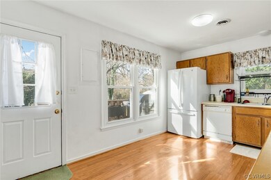 Kitchen featuring a wealth of natural light, white appliances, sink, and light hardwood / wood-style flooring
